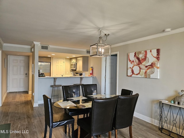 dining room featuring dark wood-type flooring, a notable chandelier, and ornamental molding