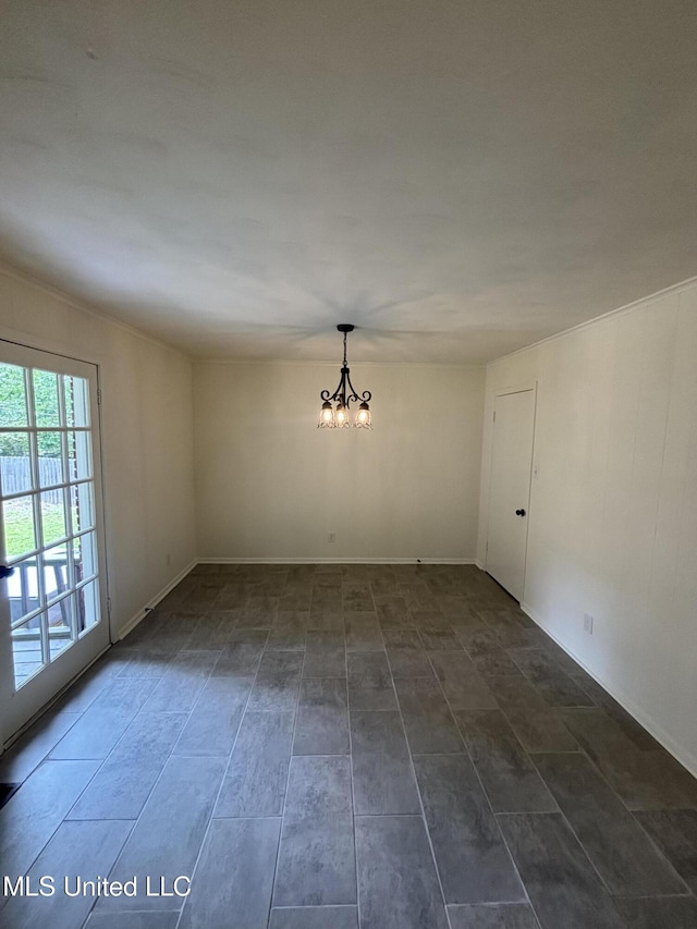 spare room with baseboards and a notable chandelier