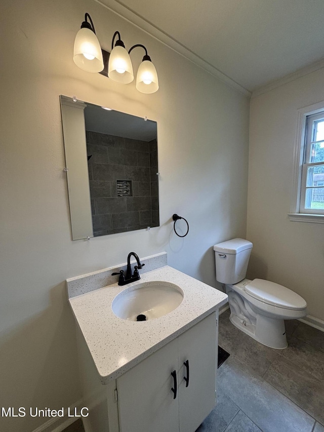 bathroom featuring toilet, ornamental molding, and vanity