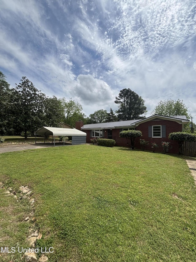 view of front of home featuring driveway, a front yard, and a carport