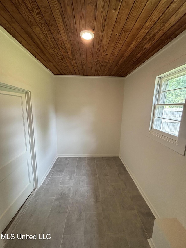 spare room featuring wood ceiling and baseboards