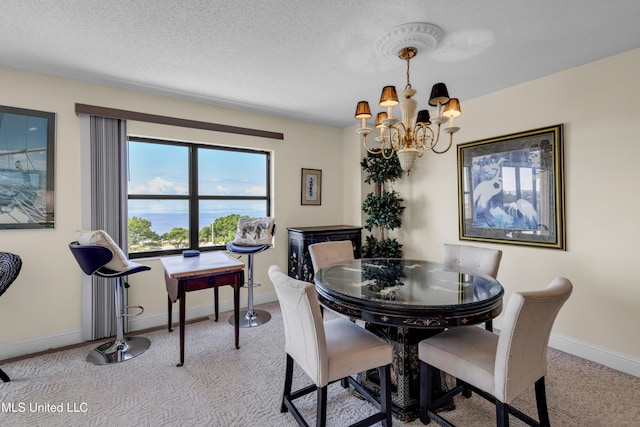1130 Beach Blvd Unit 503, Biloxi, MS 39530 - dining room featuring light carpet, a chandelier, baseboards, a textured ceiling, and a water view