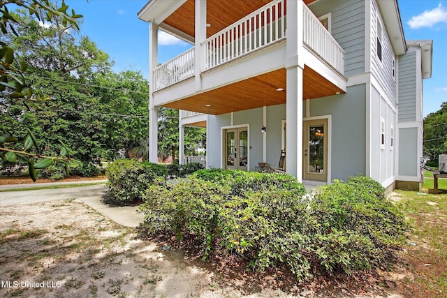 631 2nd St, Gulfport, MS 39501 - view of side of home featuring french doors, a balcony, and stucco siding