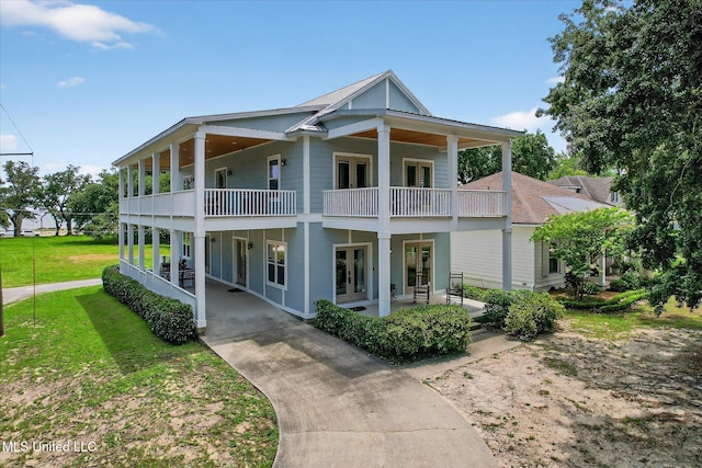 631 2nd St, Gulfport, MS 39501 - view of front of house featuring french doors, a balcony, concrete driveway, a front lawn, and a patio area