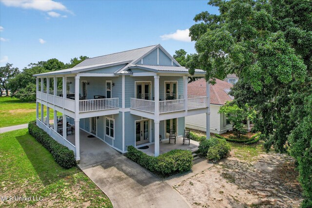 631 2nd St, Gulfport, MS 39501 - view of front of house featuring a balcony, french doors, a patio, a metal roof, and driveway