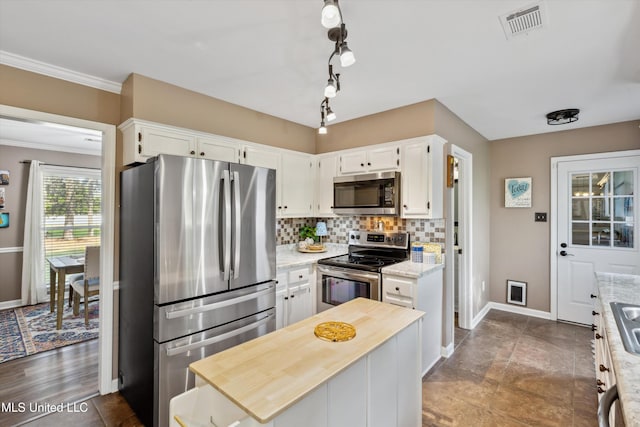 7465 Davidson Rd, Olive Branch, MS 38654 - kitchen with stainless steel appliances, decorative backsplash, white cabinetry, baseboards, and ornamental molding