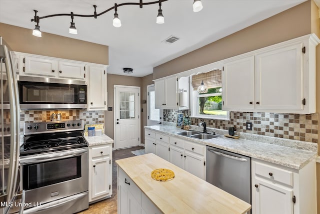 7465 Davidson Rd, Olive Branch, MS 38654 - kitchen with appliances with stainless steel finishes, a sink, backsplash, and white cabinets