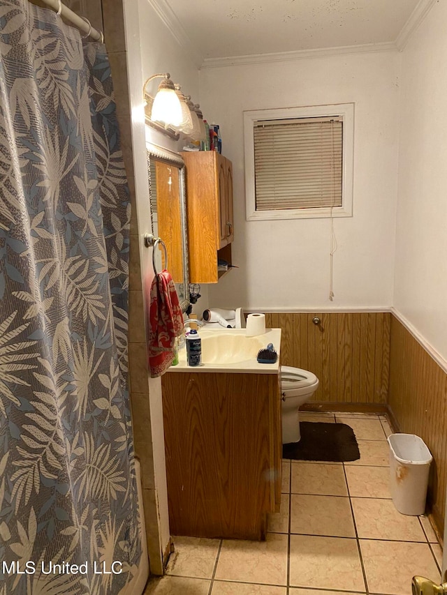 bathroom featuring vanity, wooden walls, crown molding, and toilet