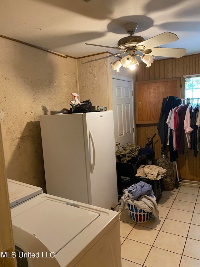 laundry room with ceiling fan, washer / clothes dryer, light tile patterned floors, and wooden walls