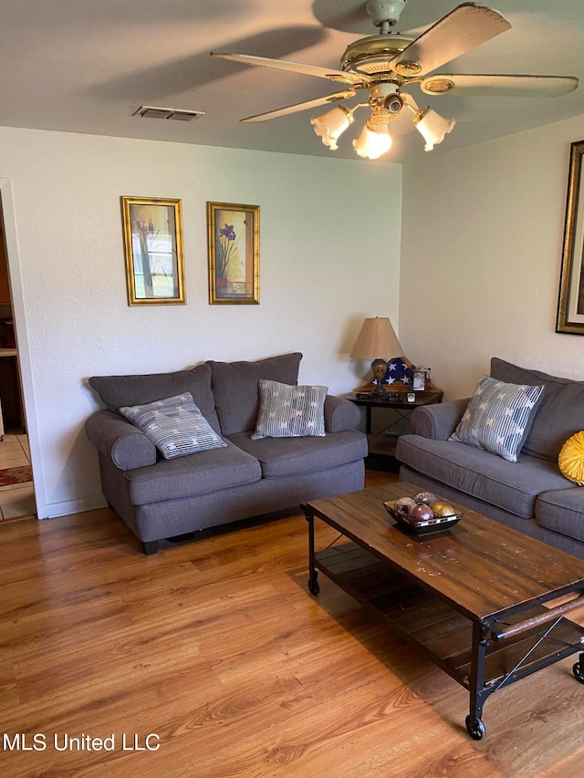 living room with light hardwood / wood-style flooring and ceiling fan