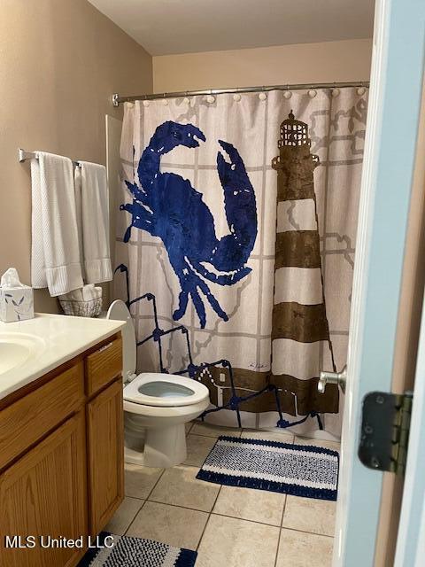 bathroom featuring tile patterned flooring, vanity, a shower with curtain, and toilet