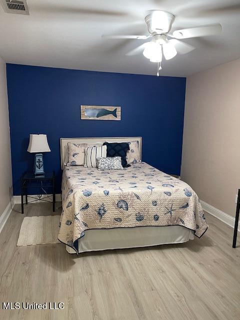 bedroom with ceiling fan and light wood-type flooring