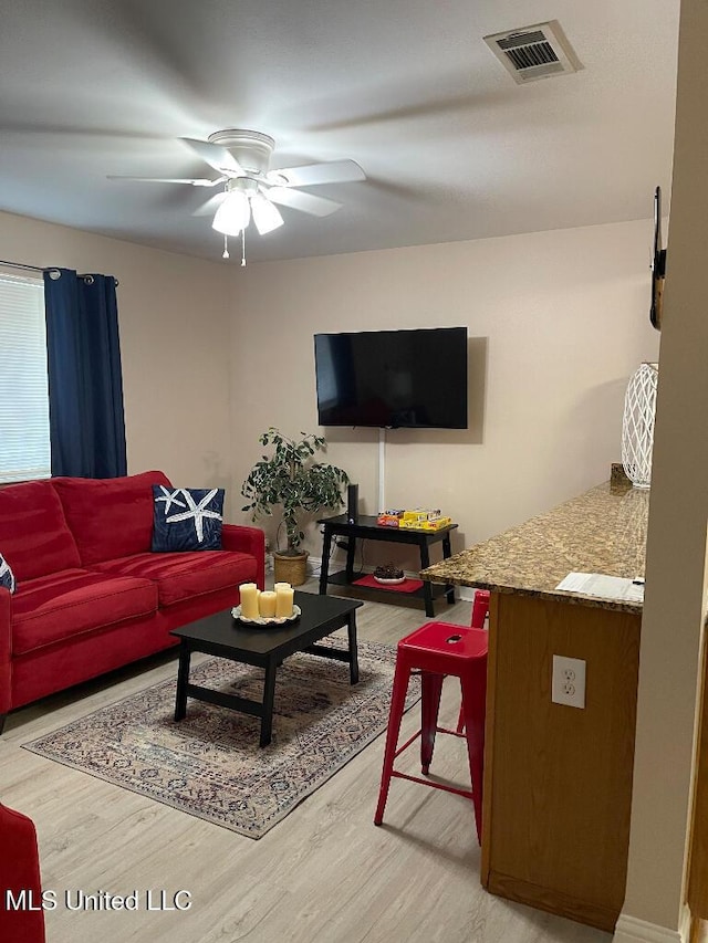 living room with wood-type flooring and ceiling fan