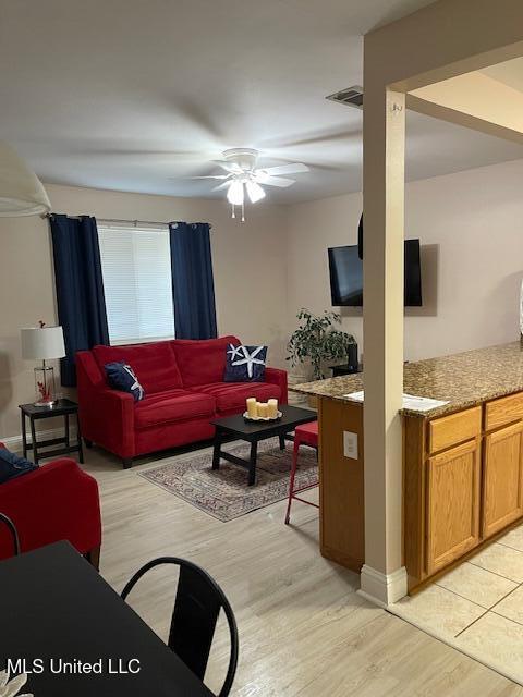 living room featuring ceiling fan and light hardwood / wood-style floors