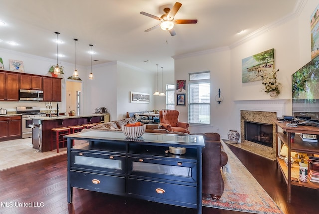 2018 Pelican Cir, Long Beach, MS 39560 - kitchen featuring appliances with stainless steel finishes, a kitchen island with sink, open floor plan, dark wood-style flooring, and ornamental molding
