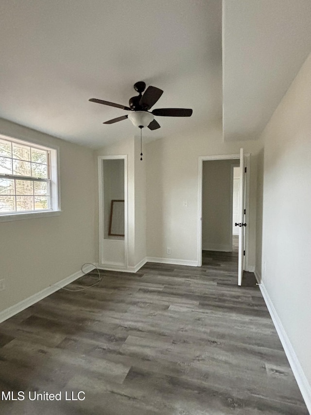 spare room with ceiling fan, dark hardwood / wood-style floors, and vaulted ceiling