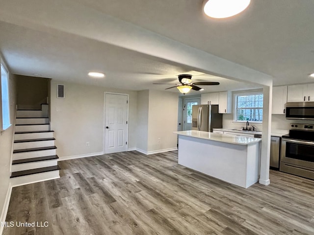 kitchen featuring sink, ceiling fan, stainless steel appliances, hardwood / wood-style floors, and white cabinets