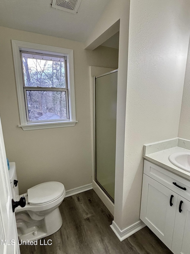 bathroom with hardwood / wood-style flooring, vanity, and an enclosed shower