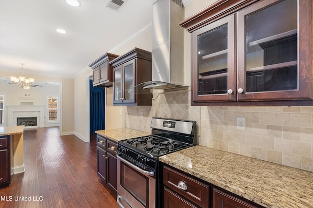 kitchen featuring stainless steel gas stove, crown molding, dark hardwood / wood-style flooring, light stone countertops, and wall chimney range hood