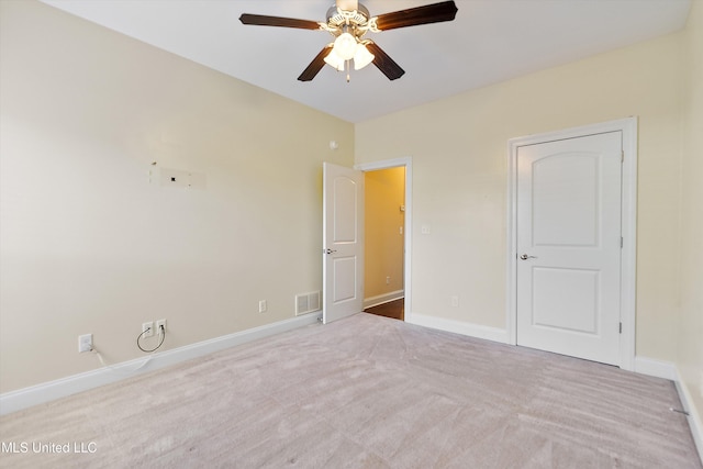 carpeted spare room with ceiling fan