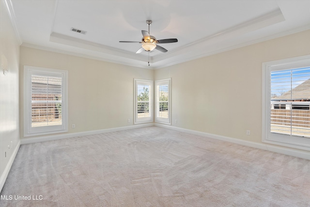 carpeted spare room with ornamental molding, a raised ceiling, and ceiling fan