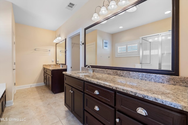 bathroom featuring tile patterned floors, vanity, and a shower with shower door