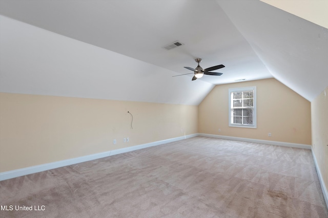 additional living space featuring ceiling fan, light colored carpet, and lofted ceiling