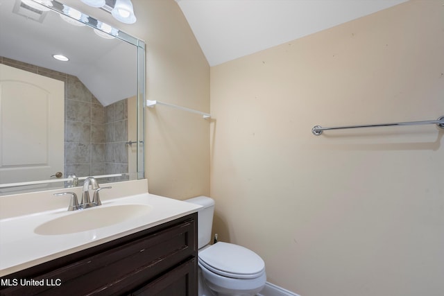 bathroom featuring vanity, lofted ceiling, and toilet