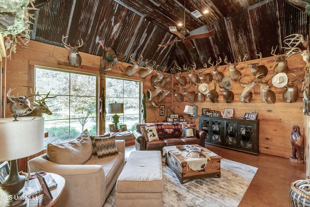 living room featuring wood walls, plenty of natural light, and ceiling fan