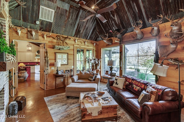 living room featuring wood walls, high vaulted ceiling, and ceiling fan