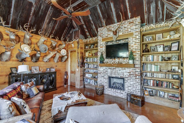 living room with vaulted ceiling, ceiling fan, wooden walls, hardwood / wood-style flooring, and a fireplace