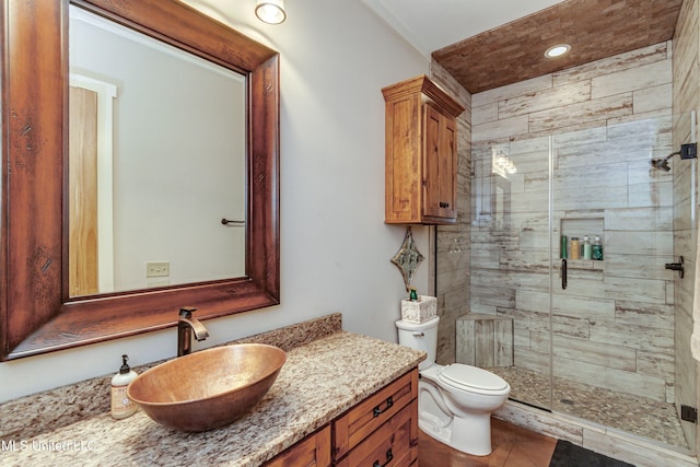 bathroom featuring tile patterned floors, vanity, toilet, and a shower with shower door