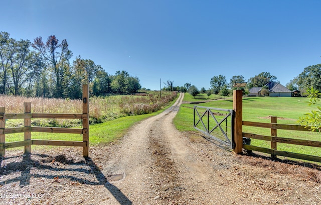 view of gate featuring a rural view and a yard