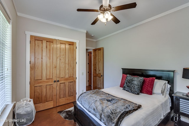 bedroom featuring ceiling fan, dark tile patterned floors, crown molding, and a closet