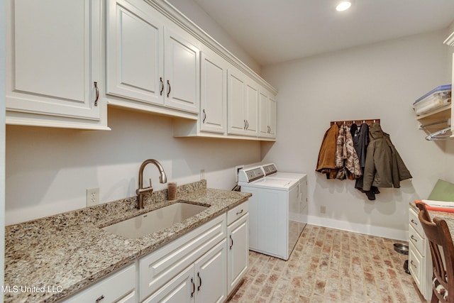 washroom with washer and clothes dryer, cabinets, and sink