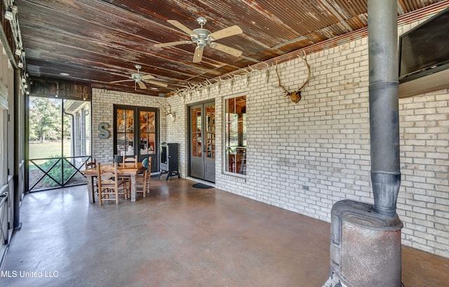 unfurnished sunroom featuring a wood stove and french doors
