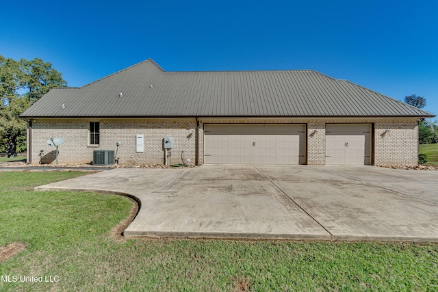rear view of house featuring a garage and a lawn