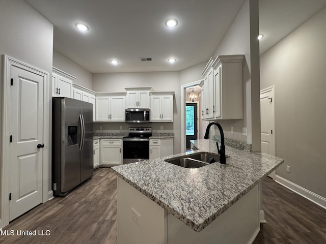 kitchen featuring a peninsula, dark wood-type flooring, white cabinets, a sink, and appliances with stainless steel finishes