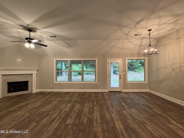 unfurnished living room featuring vaulted ceiling, dark wood-style floors, a wealth of natural light, and a fireplace