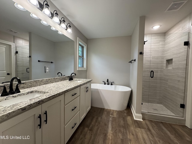 bathroom with visible vents, a sink, and wood finished floors