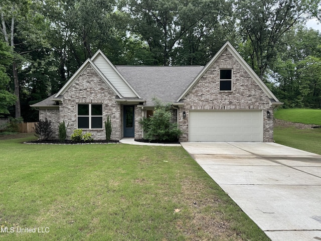 view of front of house featuring brick siding, driveway, a shingled roof, and a front yard