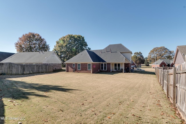 rear view of property featuring a lawn