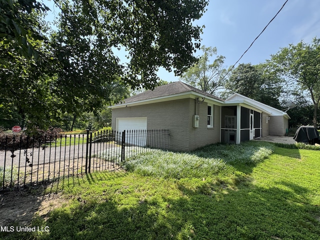 2293 Elm St, Hernando, MS 38632 - view of home's exterior featuring an attached garage, brick siding, a sunroom, and driveway