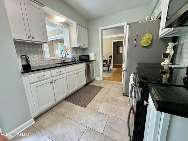 2293 Elm St, Hernando, MS 38632 - kitchen with a sink, appliances with stainless steel finishes, dark countertops, backsplash, and white cabinetry