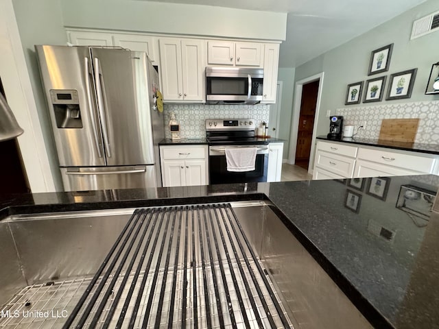 2293 Elm St, Hernando, MS 38632 - kitchen with stainless steel appliances, decorative backsplash, and white cabinetry