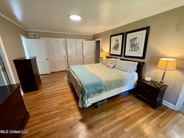 2293 Elm St, Hernando, MS 38632 - bedroom with wood finished floors, multiple closets, crown molding, and baseboards