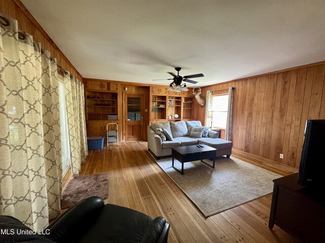 2293 Elm St, Hernando, MS 38632 - living room featuring hardwood / wood-style flooring, wooden walls, a ceiling fan, and built in features