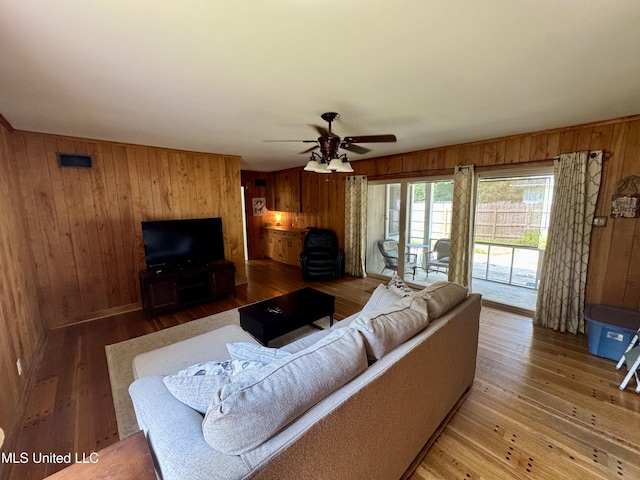 2293 Elm St, Hernando, MS 38632 - living area with wood walls, a ceiling fan, and hardwood / wood-style flooring