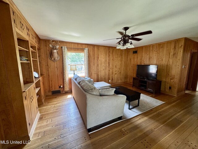 2293 Elm St, Hernando, MS 38632 - living room featuring light wood-style flooring, a ceiling fan, and wood walls