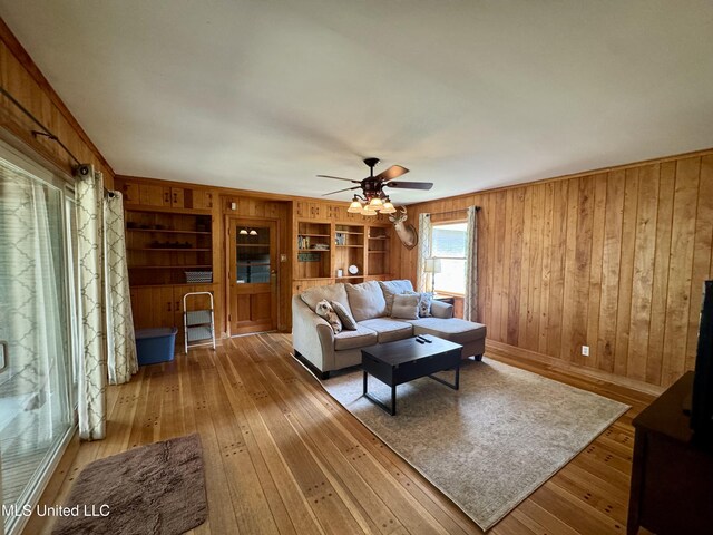 2293 Elm St, Hernando, MS 38632 - living area with hardwood / wood-style floors, wood walls, ceiling fan, and baseboards